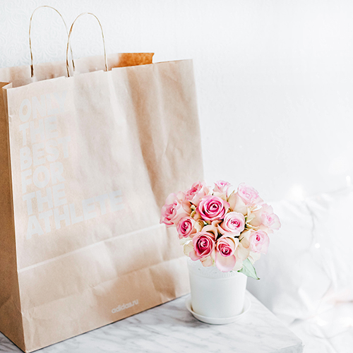 Shopping bag next to flowers in a vase
