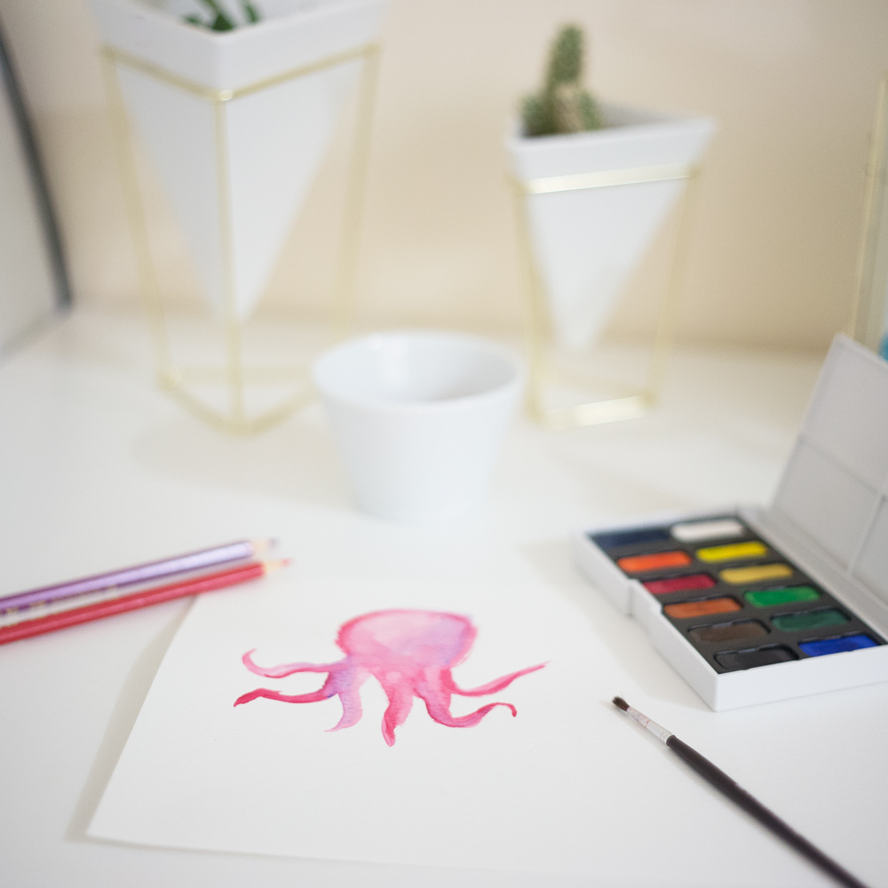 Watercolour octopus on table with supplies