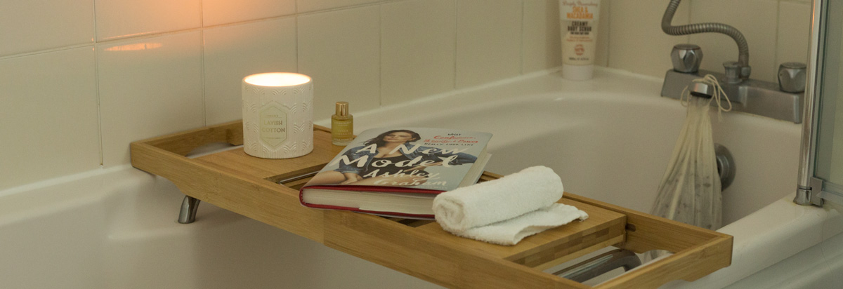 Ashley Graham book on a bath shelf next to a candle